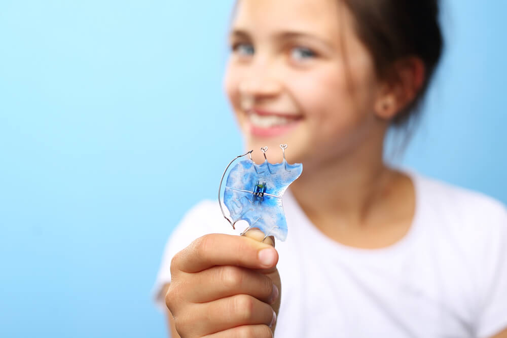 Kid showing her retainer with pearl city dental