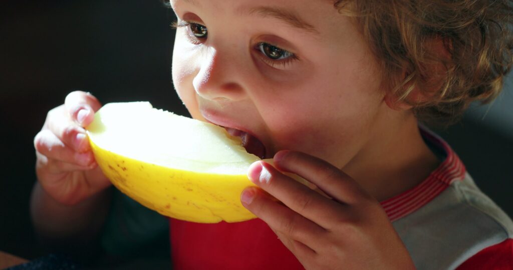 Boy-Eating-Fruit-as-the-Pediatric-Dentist-in-Kapolei-Instructed
